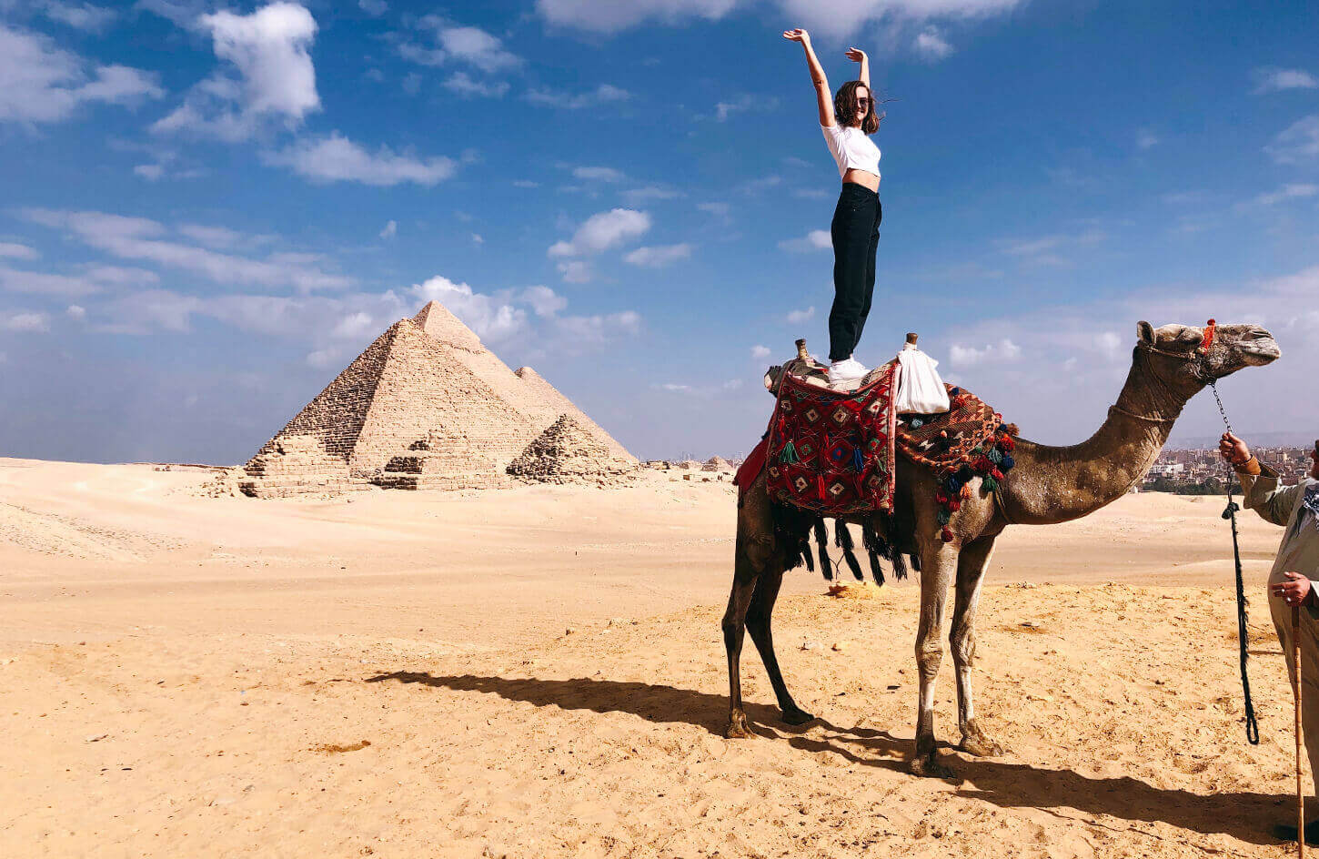 great-shot-of-a-female-tourist-standing-on-a-camel